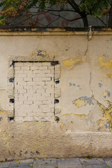 Texture of a brick wall with old, peeling paint in some partially ruined buildings