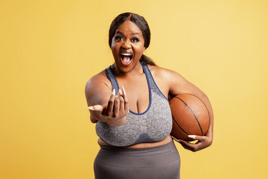 Plus size woman holding basketball inviting players - Powered by Adobe