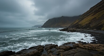 Obraz premium Dramatic coastal view on a dreary, overcast day. Gray skies meet the cold ocean waves crashing onto the rugged beach, emphasizing solitude and natural power ,sea ,water ,outdoor