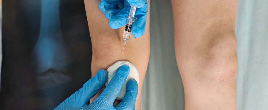 Doctor gives an injection to a patient, a child teenager, in a clinic