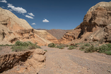 Wind blown and carved rock formation canyon. Sunny day, blue sky in the background. Kyrgyzstan, Central Asia.