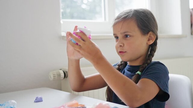 child explores bright slime textures, playful child ventures into vibrant slime textures during activity, young girl enjoys testing and exploring various bright slime textures in play area