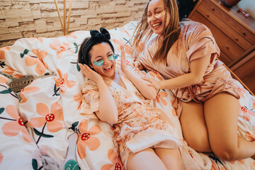 Two women sharing a joyful moment on a floral bed during a skincare routine, enhancing friendship and relaxation.
