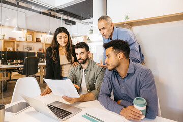 Business team collaborating on project in modern office