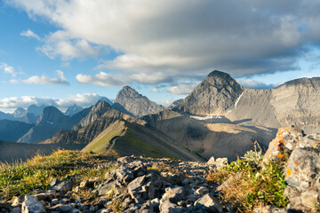 Panoramic mountain range view under blue sky with fluffy clouds and sunshine. © Viks