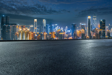 Empty asphalt road and modern city skyline at night.