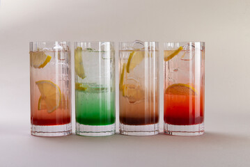 Sparkling water with various syrups in glasses.
