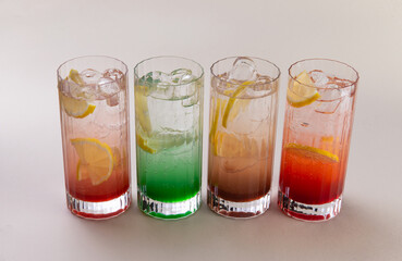 Sparkling water with various syrups in glasses.