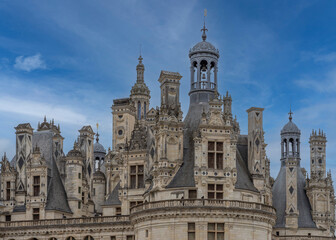 Naklejka premium Chambord, France - 10 27 2025: Detail view of the Chambord Castle roof with balconies, towers, bell towers and chimneys