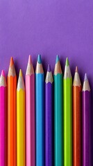 Elegant photo of row of colorful sharpened pencils on a purple background.
