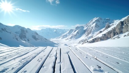 Rustic wooden surface dusted with snow against backdrop of majestic snow capped mountains and bright sunlit blue sky. Ideal for product placement, winter promotions, and advertising campaigns.