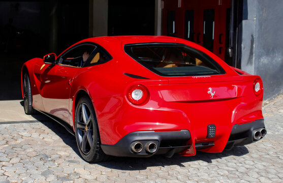 Red Ferrari F12 Berlinetta rear view, Italian supercar parked in garage