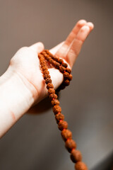 Japamala from Rudraksha on the hand. Prayer beads. Religious equipment	

