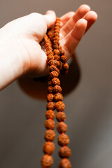 Japamala from Rudraksha on the hand. Prayer beads. Religious equipment	
