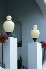 street lamps and bright pink and purple flowers in pots near the building