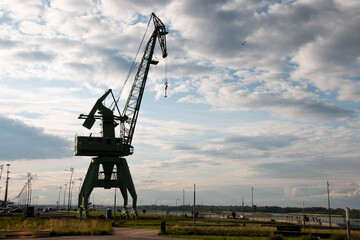 Fototapeta premium Industrial Harbor Crane on a Cloudy Day Coastal Infrastructure and Maritime Equipment