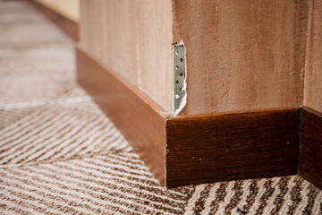 closeup of wall fixture, detailed view showing plaster damage and fastening points on wall corner
