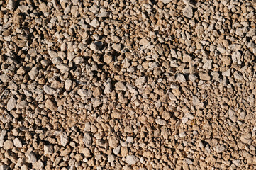 pebbled earthy surface, closeup of compacted stone and earthtoned granules for construction purposes