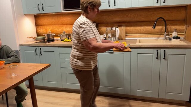 This authentic home video shows a grandmother and her grandchild engaged in the rewarding task of making natural orange juice with a manual juicer.