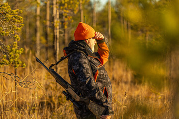 Hunter with his hunting rifle outdoor in the autumn wilderness hunting moose