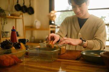 Freshly made sandwich being placed into a lunch container, showing a cozy daily meal prep routine in natural lighting