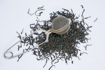 Loose Leaf Black Tea with Metal Tea Infuser on White Background