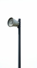 Outdoor public address horn loudspeaker mounted high on a dark utility pole against a bright white background.