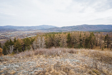 Calm pastoral views, Gentle rural scenery with hills, Serene countryside featuring autumn foliage and rugged hills, Quiet village outskirts surrounded by mountains and vibrant seasonal