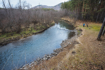 Tranquil river edge with solitary observer, Silent shoreline featuring walker among colorful trees,...