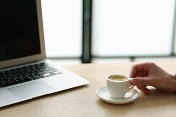 Woman having coffee break at wooden desk indoors, closeup. Space for text