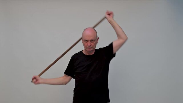Old man in sportwear practice some exercice with dumbbell

