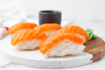 Delicious nigiri sushi with salmon on white table, closeup