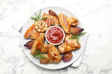Delicious grilled chicken wings served on white marble table, top view