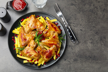 Delicious grilled chicken wings with french fries served on grey table, flat lay. Space for text
