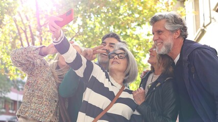 Seniors friends taking selfie with smartphone outdoors