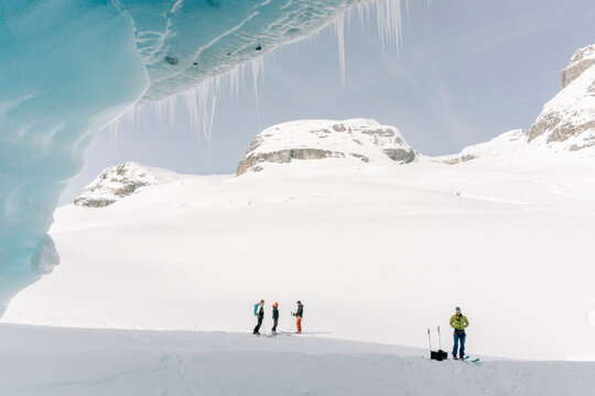 A group of skiers explore the large ice caves in the Northern Rockies of British Columbia, Canada.