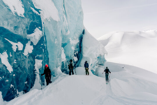 A group of skiers explore the large ice caves in the Northern Rockies of British Columbia, Canada.