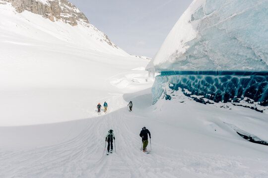 A group of skiers explore the large ice caves in the Northern Rockies of British Columbia, Canada.