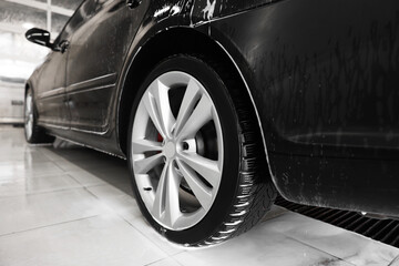 Wet black auto at car wash, closeup