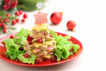 Christmas food. Fir tree made of bread, cheese, ham, lettuce and decor on white table, closeup. Space for text