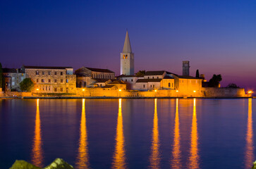 Historic European town glows at twilight, water reflects lights.&nbsp;Rovinj, Croatia