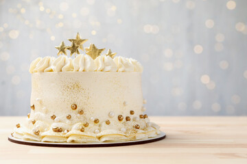 Delicious cake with Christmas decor on light wooden table against blurred lights, closeup. Space for text