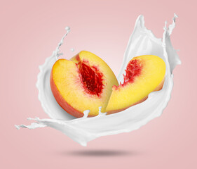 Milkshake splash and peach pieces in air on pink background