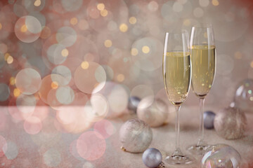 Sparkling wine in glasses and festive decor, bokeh lights. New Year greeting card