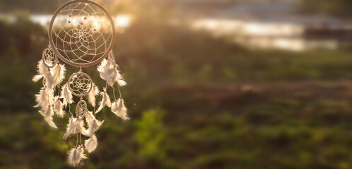 Dream catcher with feathers in nature. Banner design