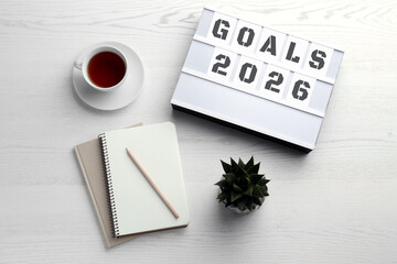 New 2026 Year Goals. Light box, notebooks and tea on table, top view