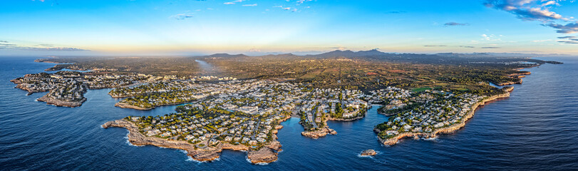 Aerial Sunrise Over Cala d'Or: Multiple Coves, Yachts, and Resort Town on Mallorca's Coast