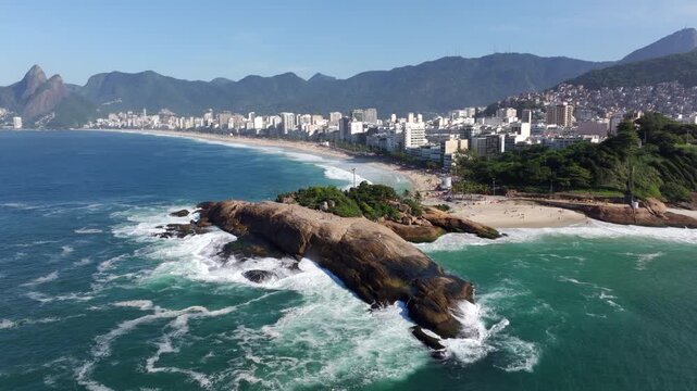 Aerial orbiting shot of Pedra do Arpoador and Ipanema Beach during summer in Rio de Janeiro, Brazil.