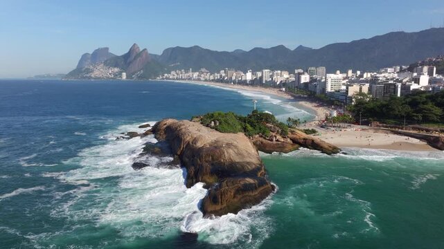 Aerial orbiting shot of Pedra do Arpoador and Ipanema Beach during summer in Rio de Janeiro, Brazil.