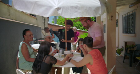 Family enjoying vibrant outdoor meal, people talking and laughing around a table, strengthening bonds and celebrating life in a friendly and relaxed atmosphere